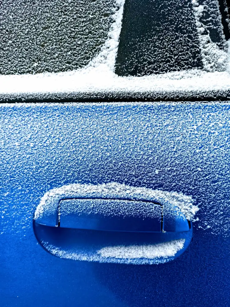 A frost-covered car door handle